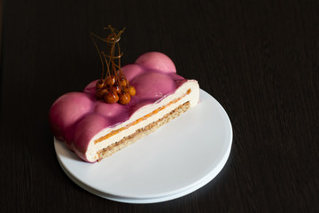 Pink cake in a cut. Nuts in caramel. Bubbles. Dark background.