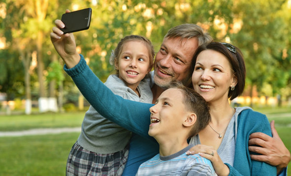 family taking selfie in park
