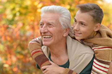 Fototapeta premium grandfather and grandson hugging in park 