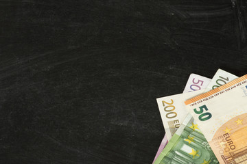 Euro Geldscheine und eine schwarze Kreidetafel als Vorlage zum Bearbeiten