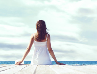 Beautiful, attractive model posing in white dress on a wooden pi