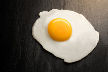 close up fried egg on black background