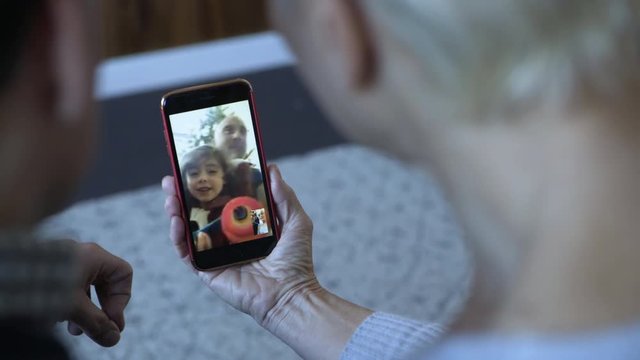 Close-up dolly shot of couple video calling on mobile phone at home