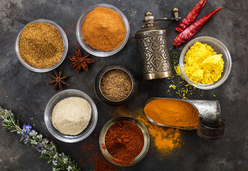 Variety of colorful spices on metal rusty background, top view