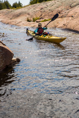 Active senior paddling a sea kayak