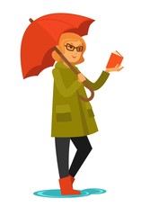 Woman in coat and rubber boots stands under umbrella