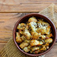 Spicy fried mushrooms. Homemade fried mushroom slices in a bowl on a wooden background. Easy cooked mushrooms. Closeup. Top view