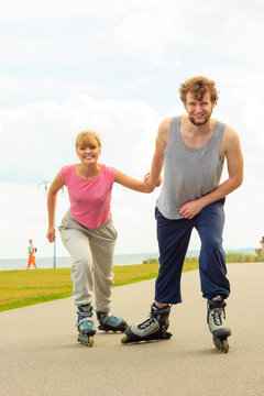 Man encourage woman to do rollerblading
