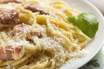 Plate with traditional Italian pasta Carbonara with grated parmesan