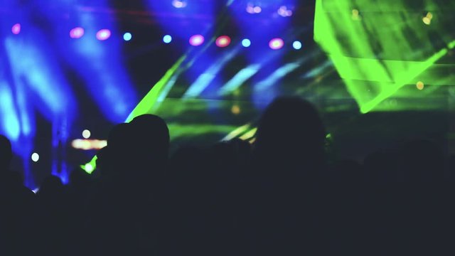 Youth Music Festival of pop music. Laser show on the stage. The crowd of fans. Bright abstract background ideal for any design. Blurred bokeh basic background for design
