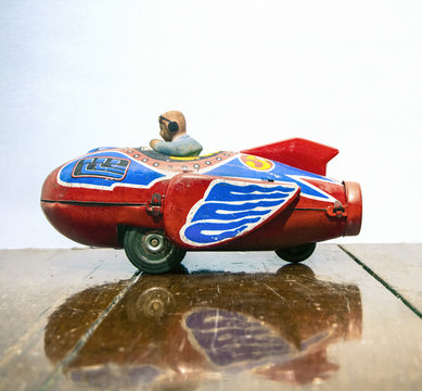 retro rocket tin toy close up on a wooden floor with reflection