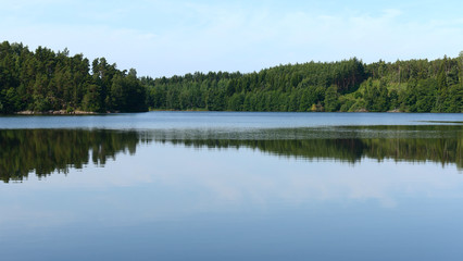 Fototapeta premium Mirror reflection of forest in still water. Aland Islands, Finland