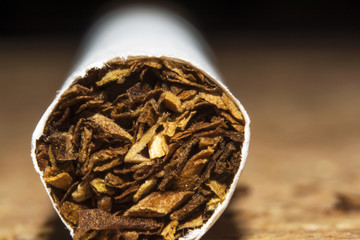cigarettes and tobacco on a brown wooden background, closeup