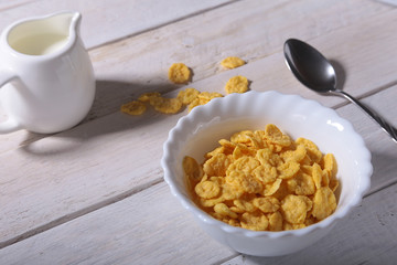 Corn Flakes cereal in a bowl and glass with milk. Morning breakfast.