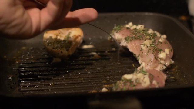 Turning Over Garlic and Rosemary Chicken in a Griddle Pan