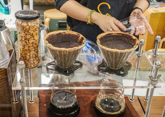 close up woman barista with hot dip coffee