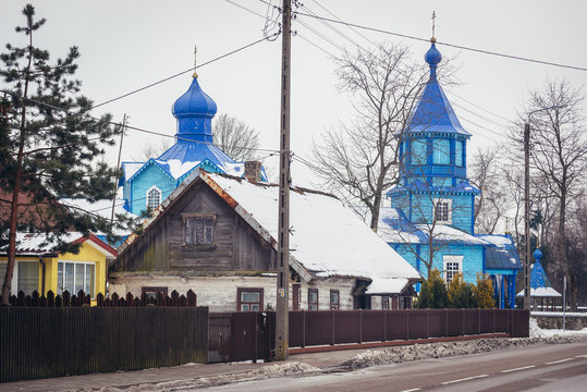Houses and Exaltation of Holy Cross wooden Orthodox church in Narew, small village in Podlasie region of Poland