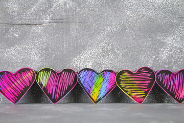 Homemade Black violet pink hearts on a gray concrete background. The concept of Valentine's Day. A symbol of love.
