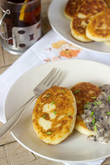 Potato cutlets or pancakes with mushroom sauce and green onions. Rustic style.