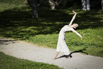 Fototapeta na wymiar Contemporary ballerina dancing in the park on a sunny day