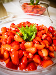 the strawberries in the glass bowl with mint leaves