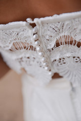 woman in white dress sitting on the beach. bride in Boho style