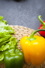 Heathy food Vegetarian Concept. Lettuce leaves and paprika peppers, dark concrete background with copy space, top view