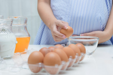 Pregnant woman preparing meal at table in the kitchen,healthy nutrition during pregnancy