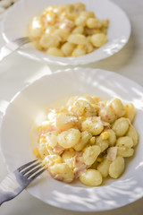 Homemade potato gnocchi with cheese and ham.