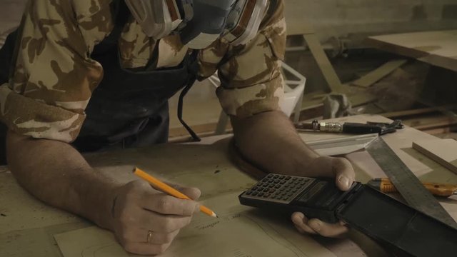 Carpenter working on a drawing, close-up, in a carpentry workshop
