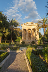 Obraz premium Ancient style Monument to Sir Alexander Ball in Lower Barrakka Gardens in Valletta, capital city of Malta. November, popular touristic attraction and destination.