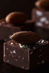Chocolate candy with nuts, almonds on a dark background.