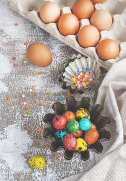 Colored easter eggs and baking molds on a light canvas background,place for text