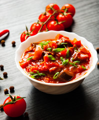 Goulash. Vegetable rague with eggplant, pepper, tomato and carrot in white bowl on dark wooden background