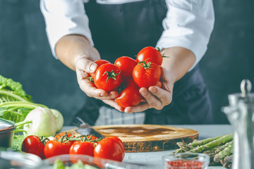 Chefkoch in der Küche mit Frischem Gemüse(Tomaten)