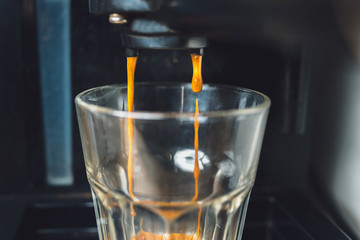 Espresso coffee preparation using coffee machine at home, shallow depth of field