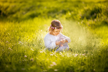 A LITTLE GIRL IN THE FLOWERING SPRING GARDEN