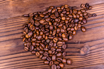 Pile of the roasted coffee beans on wooden table. Top view