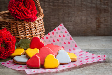 Gingerbread cookie hearts with garden roses over the wooden background. Valentine day postcard concept.