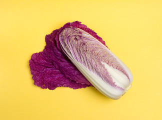 Minimal style, creative concept of fashion food. Flat lay. Food concept. Purple Chinese cabbage on a bright yellow background, top view