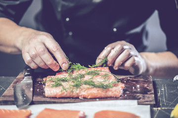 Chef Koch in der Küche (Lachs Fisch gericht)