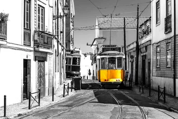 Poster Gelbe Straßenbahn auf alten Straßen von Lissabon, Portugal, beliebte Touristenattraktion und Ziel. Schwarz-Weiß-Bild mit einer farbigen Straßenbahn. © hungry_herbivore