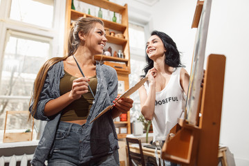 two girls in an artist studio. paints model