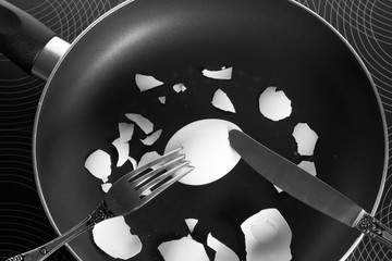 fork and knife cut egg shell in frying pan