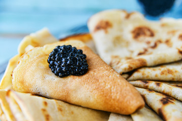 Russian Maslenitsa, pancakes with black caviar. Shrovetide, pancake week, carnival, shrove, pancake day.