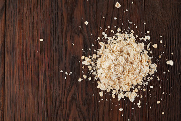 Oatmeal flakes on a wooden background. Top view.