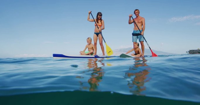 Family stand up paddle boarding in the ocean, active lifestyle