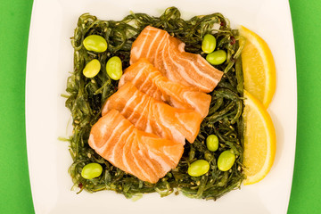 Japanese Style Salmon Sashimi On A Bed Of Pickled Seaweed Salad And Edamame Beans