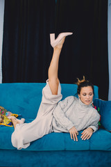 home, leisure and happiness concept - smiling teenage girl lying on sofa