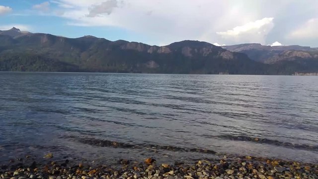 Take in Lake Traful, Villa Traful. Waves in crystal clear water with mountains in the background.